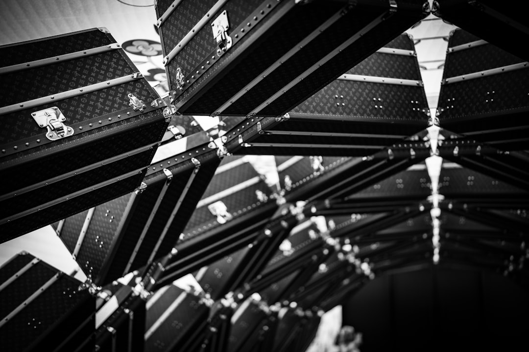 Black and white image shows many reflected suitcases.