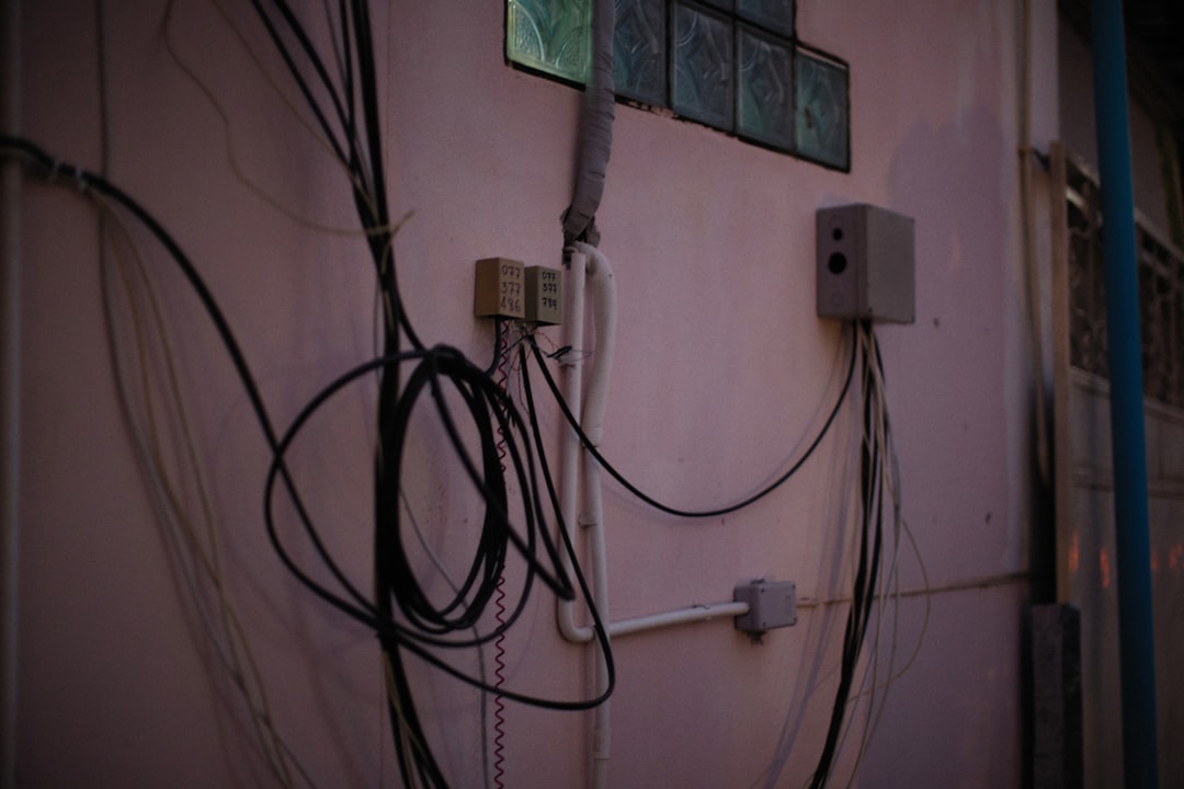 a bunch of wires hanging on the side of a building